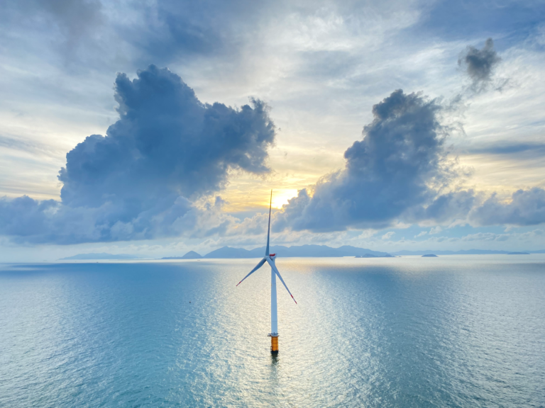 A Ming Yang offshore wind turbine standing in calm open sea at sunset